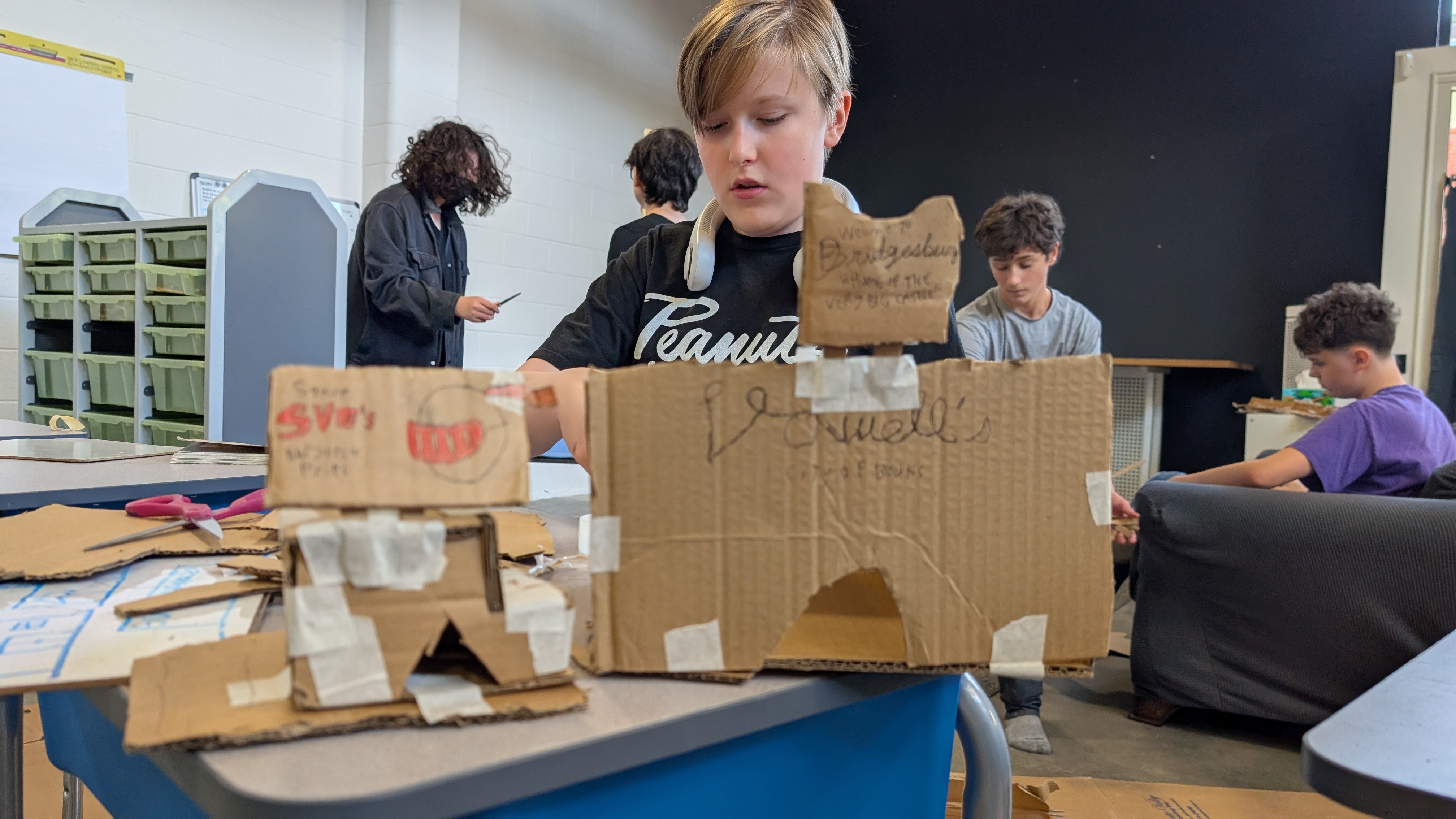 Bridges' student creating art with cardboard